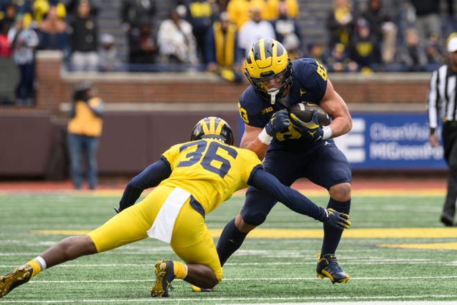 Team Blue tight end Zack Marshall tries to evade a tackle by Team Maize defensive back Keshaun Harris in the fourth quarter of the annual spring game at Michigan Stadium.