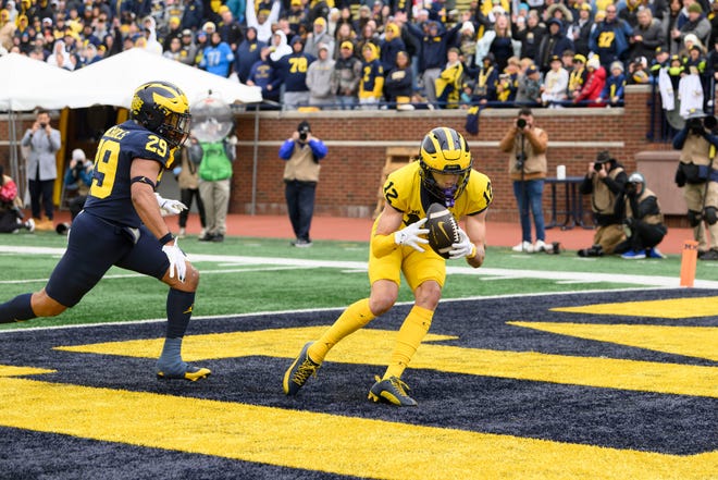 Team Maize wide receiver Kendrick Bell completes this touchdown pass ahead of Team Blue defensive back Joshua Nichols in the fourth quarter of the annual spring game at Michigan Stadium.