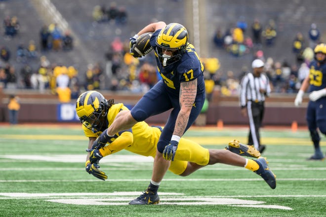 Team Blue tight end Marlin Klein evades a tackle by Team Maize defensive back Jacob Oden in the fourth quarter of the annual spring game at Michigan Stadium.