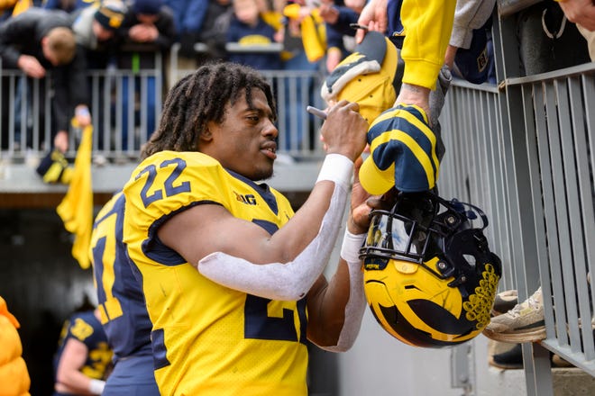 Team Maize running back Tavierre Dunlap signs autographs after the annual spring game at Michigan Stadium.