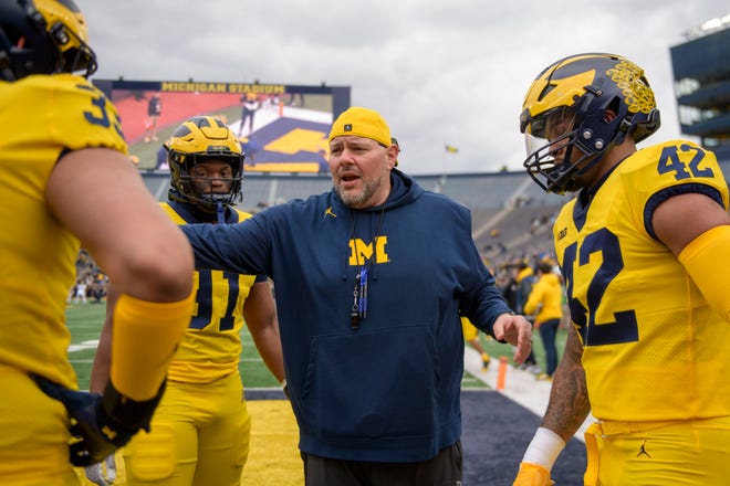 Defensive line coach Lou Esposito takes his players through drills before the start of the annual spring game at Michigan Stadium.