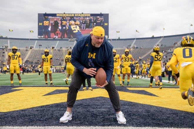 Defensive line coach Lou Esposito takes his players through drills before the start of the annual spring game at Michigan Stadium.