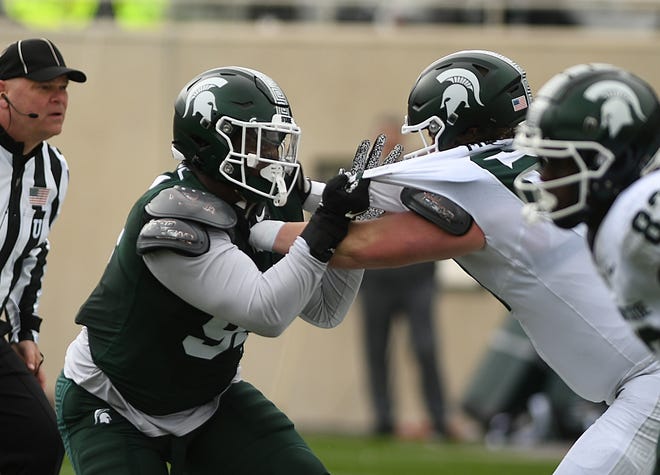 Defensive lineman D’Quan Douse battles against offensive lineman Jacob Merritt during the Michigan State football's spring showcase/scrimmage at Spartan Stadium.