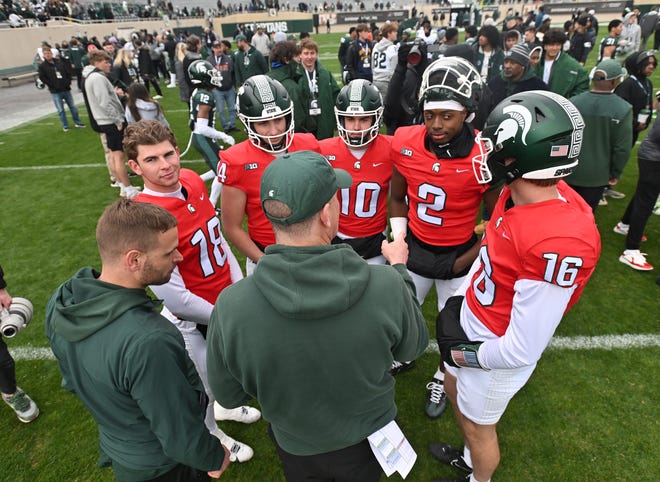 Quarterbacks Andrew Schorfhaar, Alessio Milivojevic, Tommy Schuster, Aidan Chiles and Ryland Jessee huddle after the Michigan State football's spring showcase/scrimmage at Spartan Stadium.