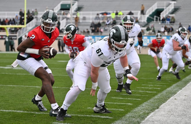 Quarterback Aiden Chiles takes the ball from center Tanner Miller during Michigan State football's spring showcase/scrimmage at Spartan Stadium in East Lansing, Michigan on April 20, 2024.
