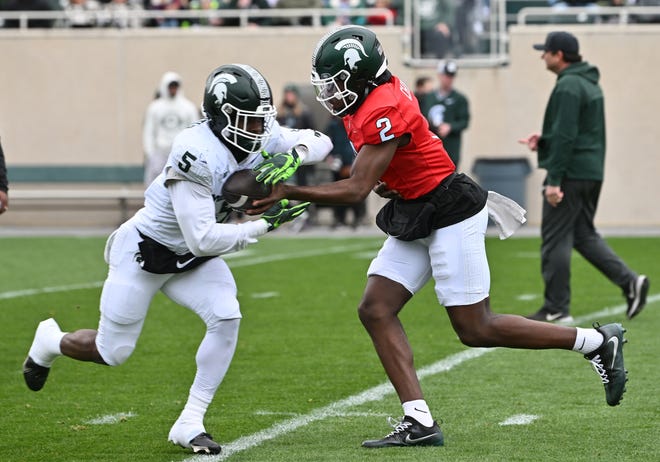 Running back Nathan Carter takes the handoff from quarterback Aidan Chiles during Michigan State football's spring showcase/scrimmage at Spartan Stadium in East Lansing, Michigan on April 20, 2024.