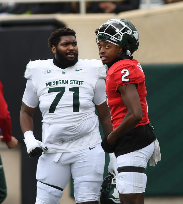 Offensive lineman Kristian Phillips talks with quarterback Aidan Chiles at Michigan State football's spring showcase/scrimmage at Spartan Stadium in East Lansing, Michigan on April 20, 2024.