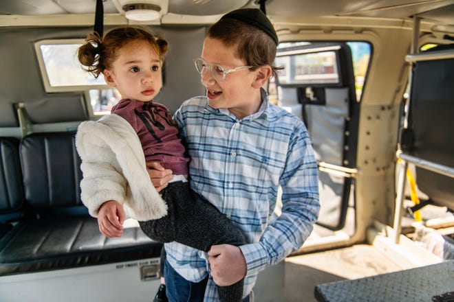 Shnuel Amsal of Oak Park, 12, holds onto his niece, Hadassah Kraushar of New Jersey, 2, as they explore a Southfield Police tactical vehicle during a free Touch-a-Truck event hosted by the Southfield Parks & Recreation Department on Sunday, April 21, 2024 at the Southfield Municipal Complex.