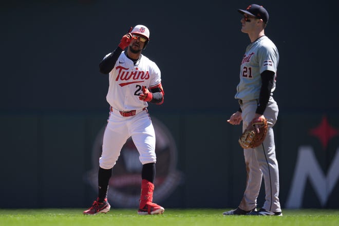 Minnesota Twins' Byron Buxton, left, points after hitting a single during the first inning.