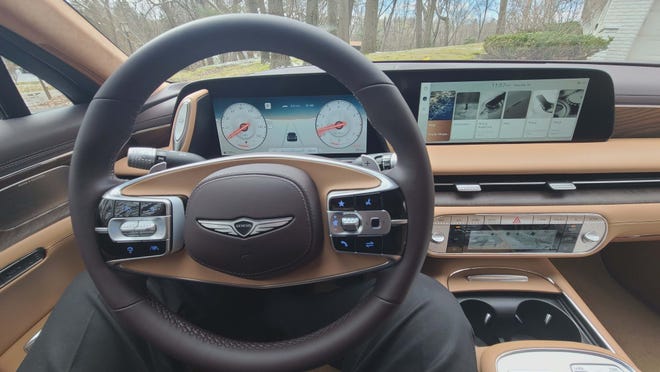 The cockpit and cool wheel design (which includes a Mercedes-like touchpad) of the 2024 Genesis G90.