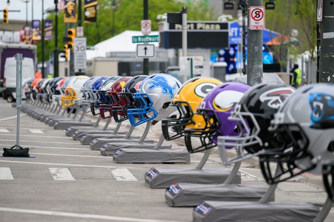 Rows of football helmets line Jefferson Ave. at the NFL Draft experience, at Hart Plaza, in Detroit, April 24, 2024.