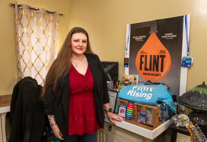 Clean water activist Melissa Mays pose for a portrait alongside a poster for the 2020 documentary film "Flint: Who Can You Trust?" on Wednesday, April 24, 2024 at her home in Flint, Michigan.