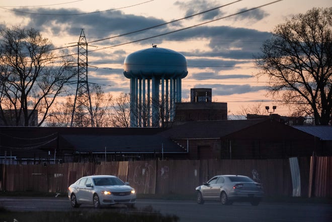 The water tower located at the City of Flint Water Plant is silhouetted against the sunset on Friday, April 19, 2024 in Flint.