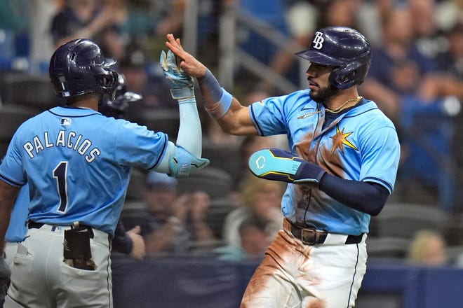 Tampa Bay Rays' Jose Caballero, right, celebrates with Richie Palacios after scoring on an RBI single by Yandy Diaz off Detroit Tigers starting pitcher Jack Flaherty during the second inning.