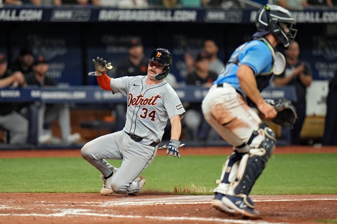Detroit Tigers' Jake Rogers (34) scores around Tampa Bay Rays catcher Ben Rortvedt on a two-run single by Mark Canha during the fifth inning.