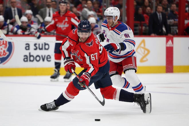 Ex-Wolverine Max Pacioretty (67) shoots on goal after colliding with Rangers center Alex Wennberg (91) during the first period in Game 3 of the Stanley Cup first-round playoff series on Friday in 
Washington.