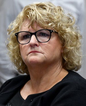 Kathie Klages listens to testimony against her by an investigator from the Attorney General's office.