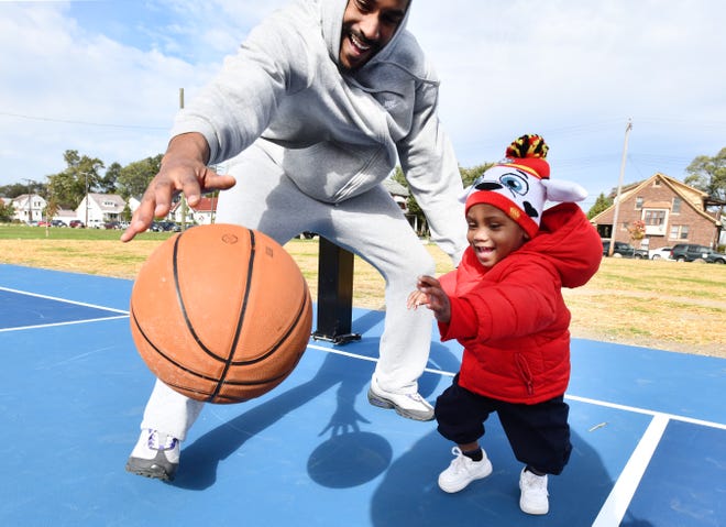 Jeffery Wilson and son Jace Wilson, 1,  try out the new basketball court at Littlefield Park in Detroit, one of 60 basketball courts that will be renovated by the Detroit Pistons by 2023.