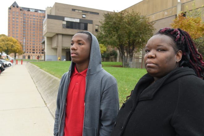 Venus Loving had only days to find a new school for her son Olonzo Prescott, 17, a high school senior, after Delta Preparatory Academy closed in September.   They chose Detroit Collegiate Preparatory High School at Northwestern (in background).
 Max Ortiz, The Detroit News