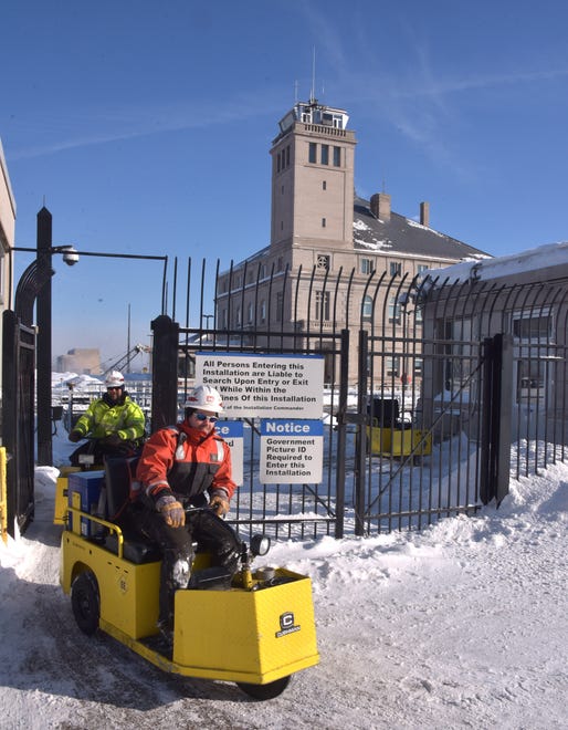 Two U.S. Army Corps of Engineers workers use small electric carts to move around the huge Soo Locks complex.