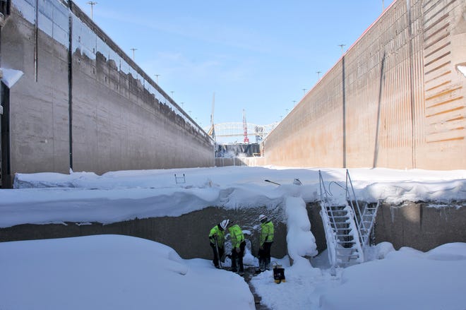 Chris Albraugh, left, Steve Robbins  and Josh Schwab work on a steam line in the Poe Lock, March 12, 2019. Steam will melt all ice and water in the lock and be drained prior to re-watering the lock on March 18.