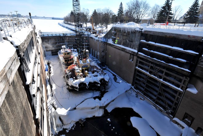 A winter maintenance work barge sits in the bottom of the MacArthur Lock Tuesday, March 12, 2019 in Sault Ste. Marie, Mich. A crane and other equipment were used for maintenance and repair over a 10-week shutdown of the facility. When water is added to the lock, the barge will be floated out to allow shipping to pass through.