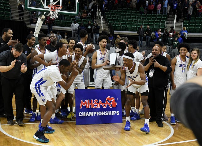 Lincoln guard Tahj Chatman (0) and Lincoln guard forward Aaron Hurling, left, dance after their team is presented with the trophy.