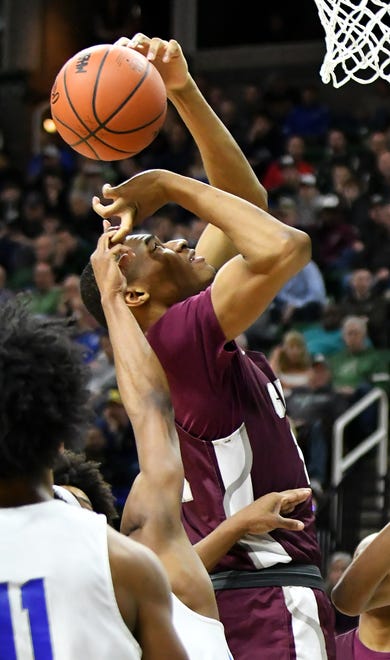 Lincoln guard Tahj Chatman (0) blocks a shot by U-D Jesuit's Jalen Thomas (11) and gets a hold of his finger in the process in the second half.