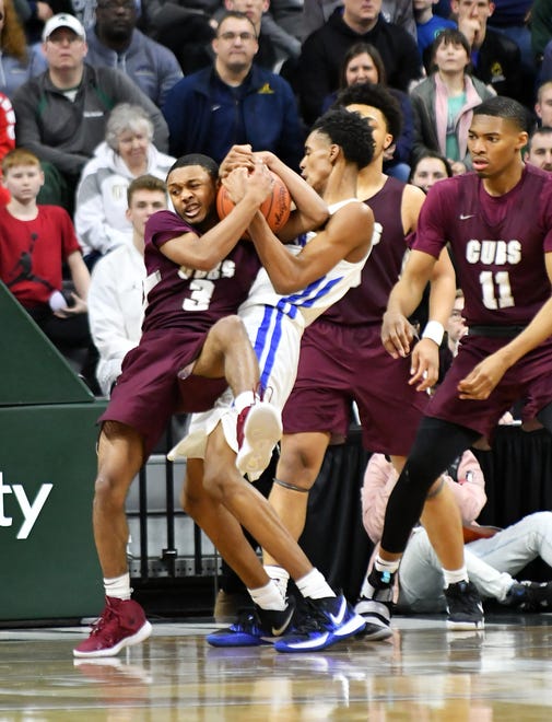 U-D Jesuit's Jordan Montgomery (3) and Lincoln's Emoni Bates (21) battle for a rebound in the last minutes of the game.