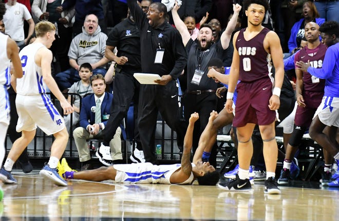 Ypsilanti Lincoln guard Jalen Fisher (14), laying on the floor, reacts after hitting the winning shot at the buzzer in a 64-62 victory over U-D Jesuit in the Division 1 final Saturday, March 16, 2019, at Breslin Center in East Lansing.