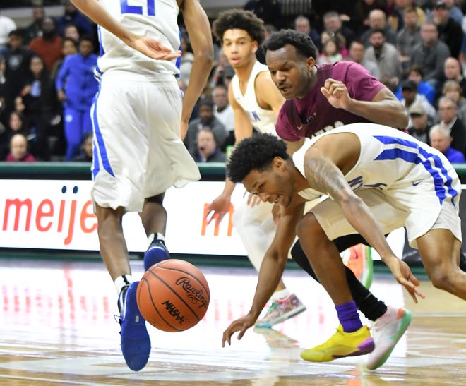 Lincoln guard Jalen Fisher, front, and U-D Jesuit's Julian Dozier (1) go for a loose ball in the second half.