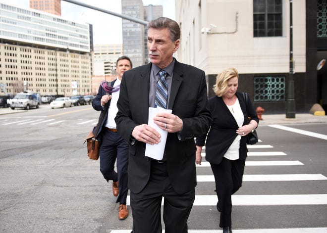 Norwood Jewell, center, leaves the U.S. courthouse  in Detroit after pleading guilty to breaking federal labor laws.