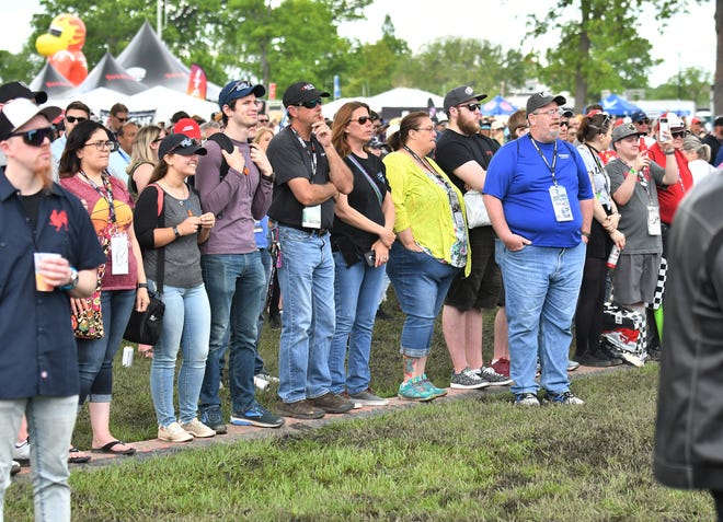 People stand on a cord coverer to stay off the wet ground while watching Stone Temple Pilots at the Chevrolet Detroit Belle Isle Grand Prix on Belle Isle.