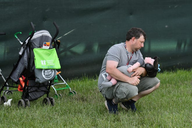 Steve Perchifkoff, 40, holds his sleeping 10-month-old, Oliver, behind Grandstand 2 after the start of the Dual II IndyCar Series Race, which quickly turned to a yellow flag.
