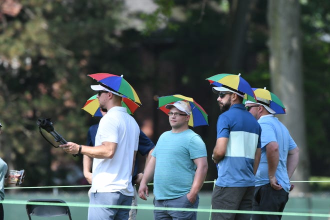 Fans wear umbrella hats along the fifth fairway.