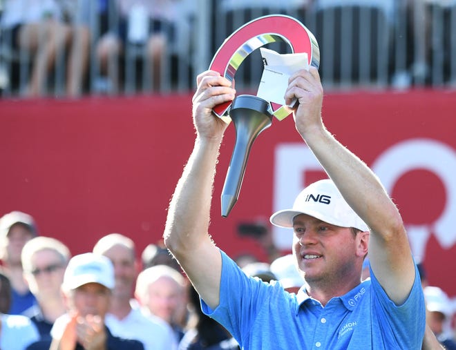 Nate Lashley holds up the Rocket Mortgage Classic trophy, his first PGA Tour victory, Sunday at the Detroit Golf Club in Detroit on June 30, 2019.