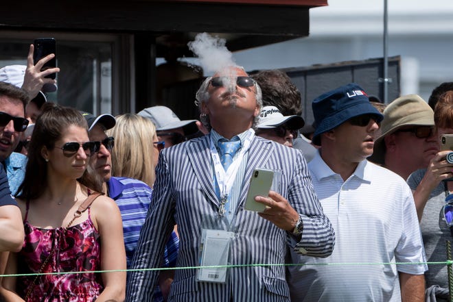Joseph Saker, of Birmingham, enjoys a cigar at the third tee during the final round of the Rocket Mortgage Classic Sunday.