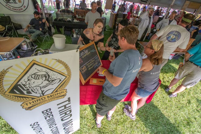 Catie Pietsch, representing Third Monk Brewing, of South Lyon, talks over beer choices with a visitor to the Michigan Brewers Guild 2019 Summer Beer Festival on Friday.