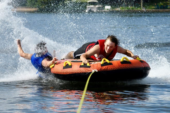" Tubing on the Lake, " by Kellie Holmstrom of Marquette. Holmstrom took her nephew Payton and his friend John tubing on Big Shag Lake in Gwinn. " They had a great time trying to stay on, " she said. " This photo catches Payton losing his grip. He came back to the boat smiling.