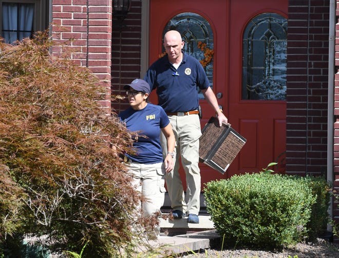 FBI investigators leave the home of UAW President Gary Jones after a search Wednesday in Canton.