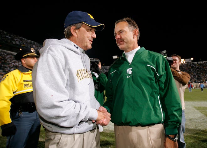 Michigan head coach Lloyd Carr, left, and Michigan State head coach Mark Dantonio shake hands after the 2007 game at Spartan Stadium.