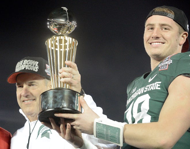 Head coach Mark Dantonio and quarterback Connor Cook hold aloft the trophy after Michigan State defeated Stanford, 24-20, in the 2014 Rose Bowl.