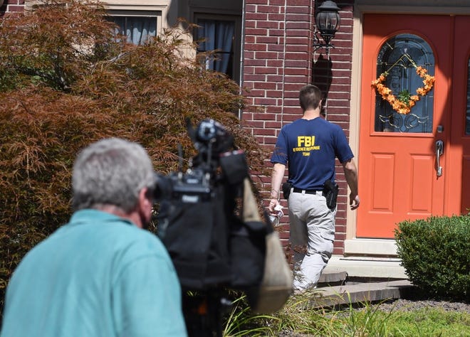 An FBI agent enters the home of UAW President Gary Jones during a search of the home in Canton Township.