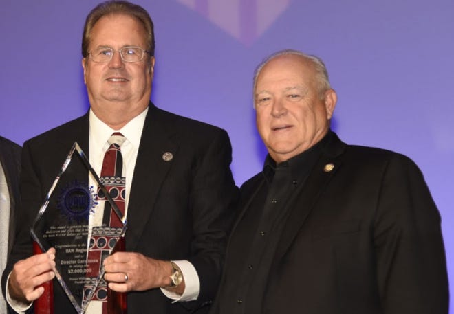 UAW President Gary Jones, left, received an award in 2018 for raising money for the union's political action committee from former UAW President Dennis Williams, right. Both of their homes were raided by federal agents Aug. 28.