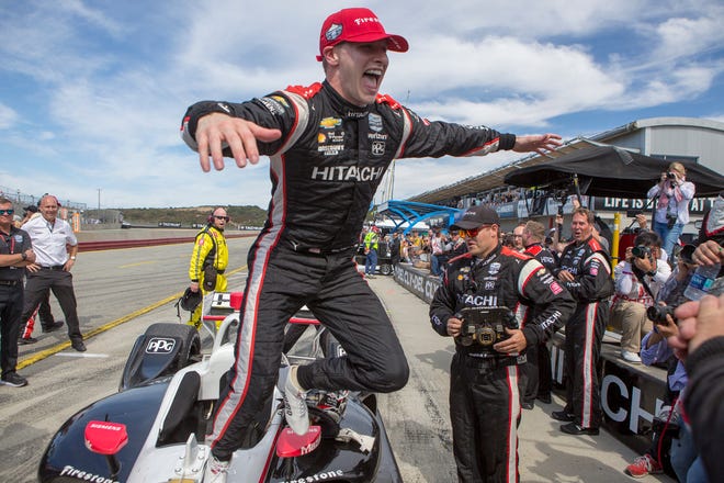 Josef Newgarden jumps from his car to celebrate with his team after winning the championship at Laguna Seca Raceway in Monterey, Calif., on Sunday.