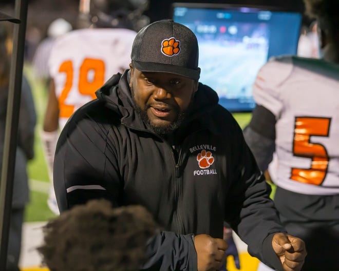 Belleville head coach Jermain Crowell talks to his players on the bench in the first half.