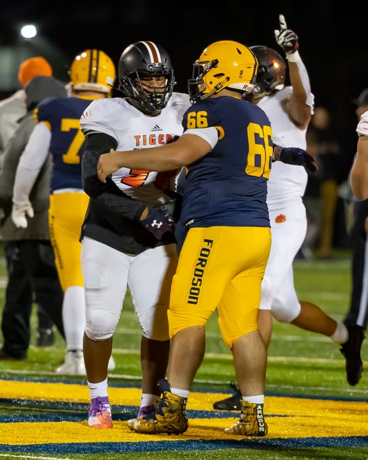 Belleville ' s Damon Payne, left, shakes hands with Fordson ' s Ali Baiz (66) after the game.