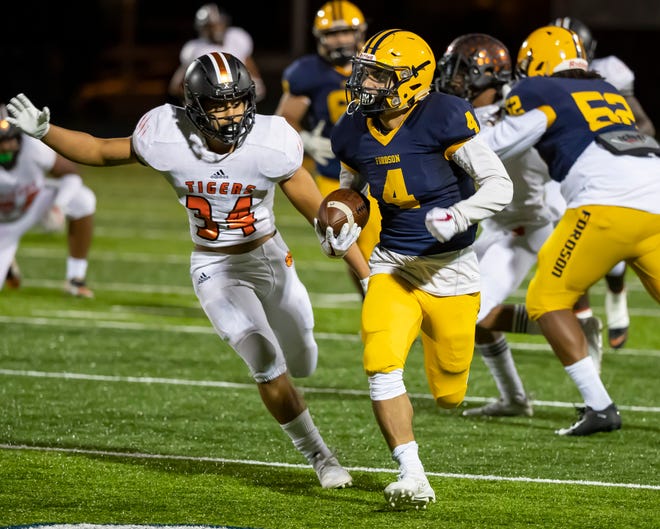 Fordson ' s Hassan Mansour (4) runs with the football in front of Belleville ' s Darian Murray (34).