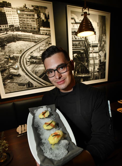 Savant owner and chef Jordan Whitmore with oysters, Champagne Sabayon, jambon and French lavender in front of artwork by local artist Lisa Spindler in Midtown, Detroit.