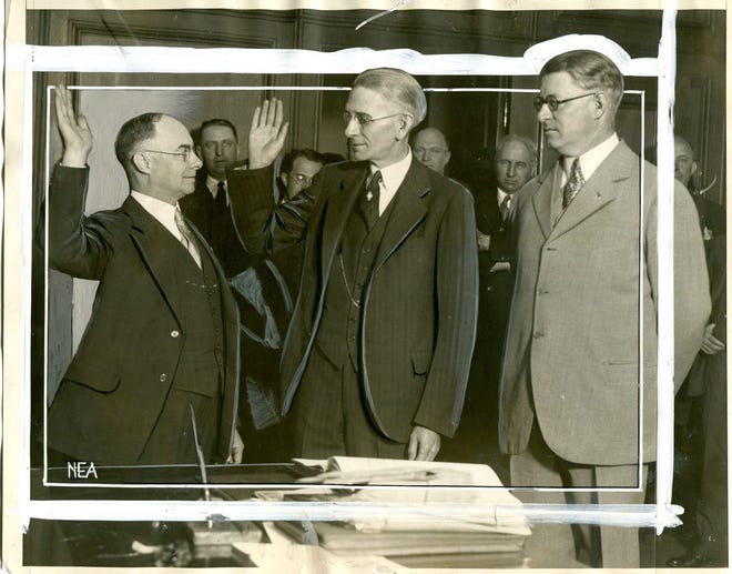 Detroit city clerk (and future mayor) Richard W. Reading, left, swears in Thomas Wilcox as Wayne County sheriff. Within a few years, both men would be indicted on graft charges and sent to prison.